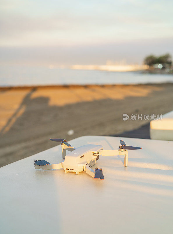 西班牙玛贝拉——2022年6月9日:大疆Mavic Mini SE无人机准备在日出时在玛贝拉海滩飞行